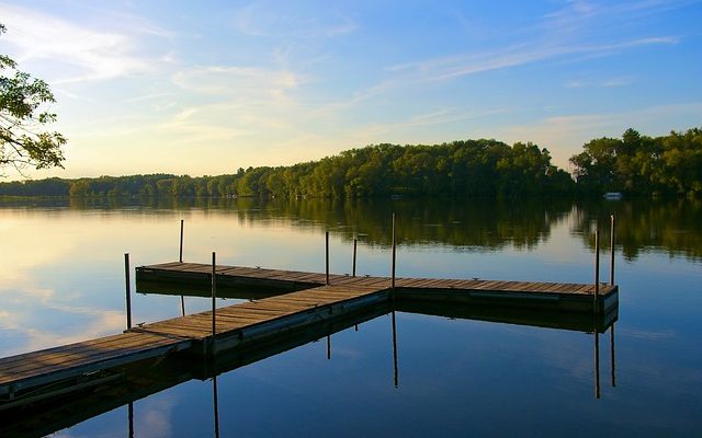 A blue sky with a large lake and a wooden dock